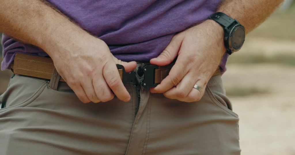 A man adjusting his Blue Alpha EDC belt.