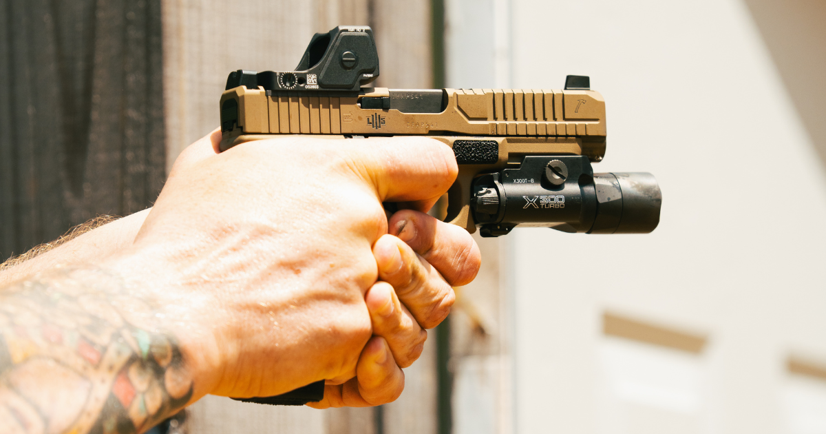A close up of a person's hands pointing a firearm .