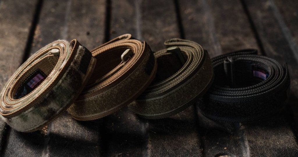 A stack of Blue Alpha EDC Belts on a table.