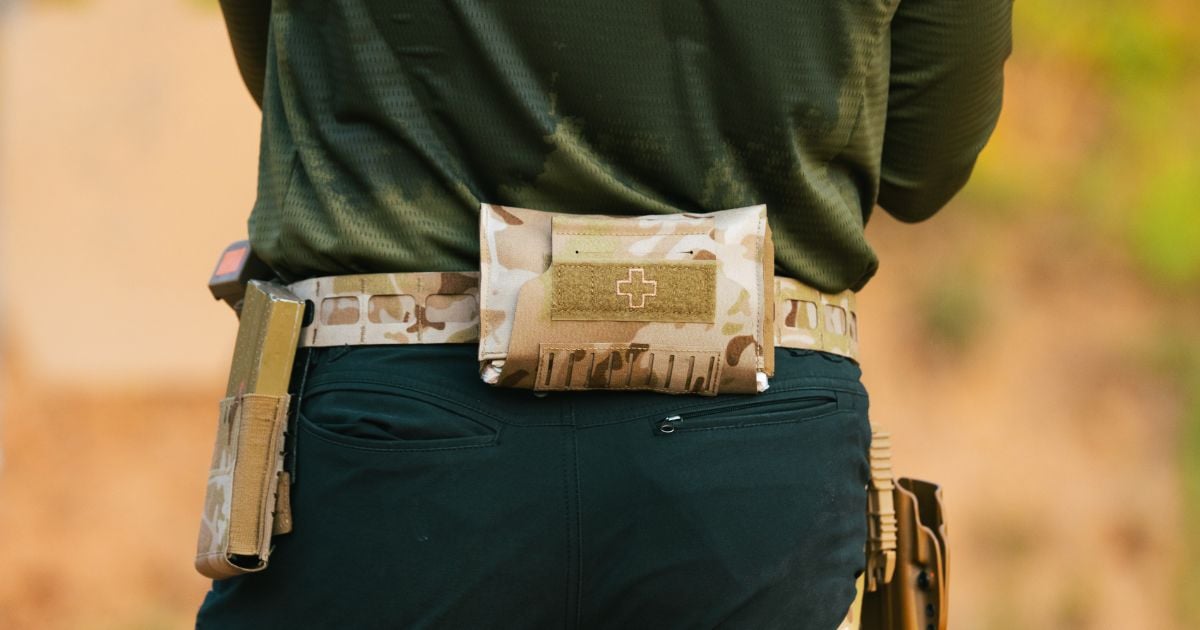 A man at a shooting range running drills using his Blue Alpa Med Pouch.