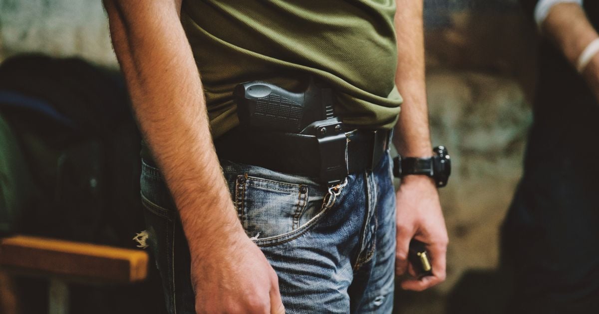 A man concealed carrying in jeans and a tshirt.