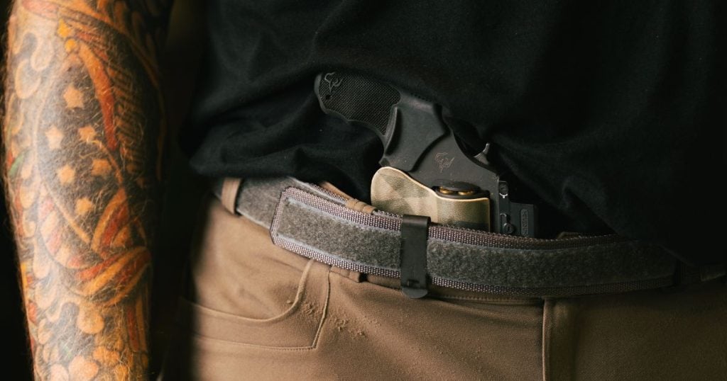 A man wearing a Blue Alpah EDC Belt for everyday carry while working from home.