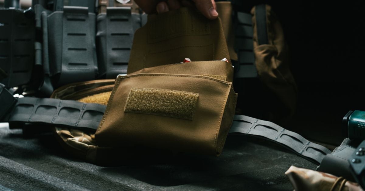 A person working on reseating his med pouch insert for proper alignment.