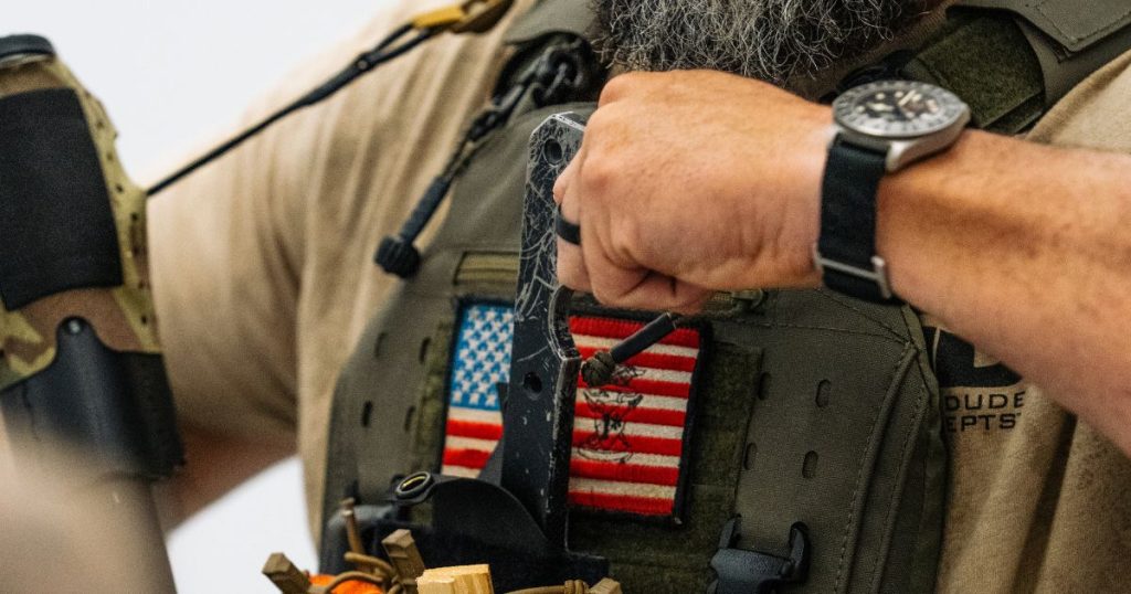 A man inserting in his BRB to his pouch on his chest carrier.