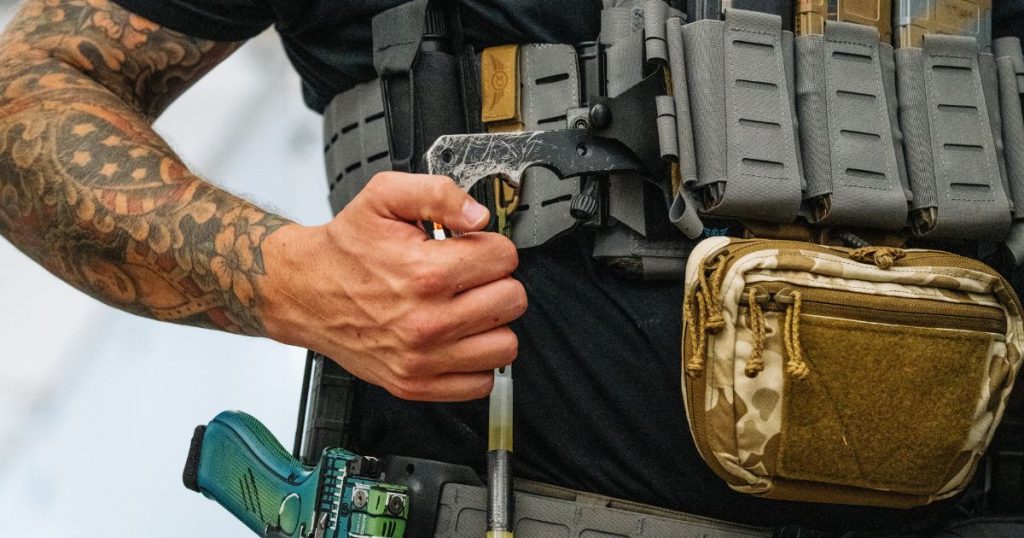 A man pushing his BRB back into his Blue Alpha BRB Pouch.
