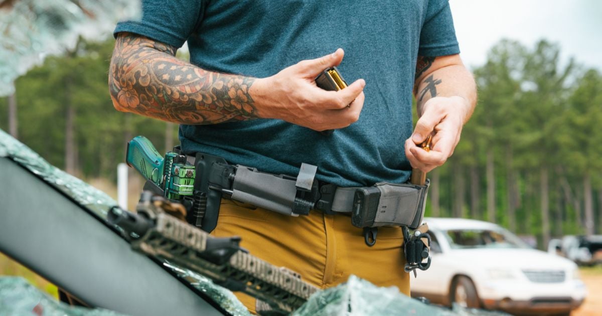 A man checking his shooting gear at the range.