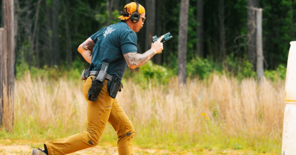 A man running with his gun at a range, testing out his gear setup.